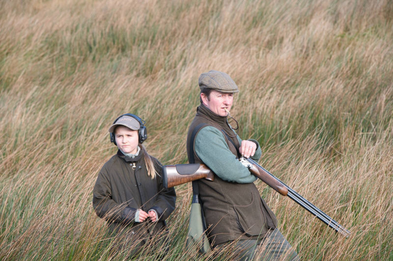 father and daughter on a rough shoot waiting for the whistle to go so they can start the drive 